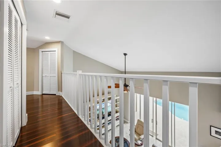 Corridor with lofted ceiling, dark wood finished floors, and recessed lighting