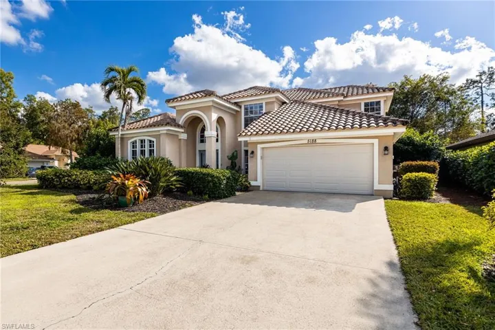Mediterranean / spanish house with stucco siding, concrete driveway, a front lawn, a garage, and a tiled roof