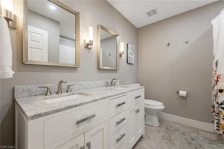 Bathroom featuring double vanity and a shower with shower curtain