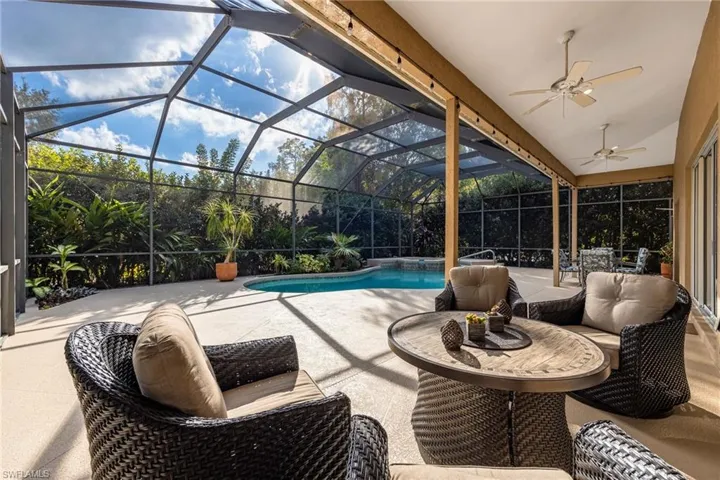 View of patio with glass enclosure, a sunroom, ceiling fan, and a pool with connected hot tub