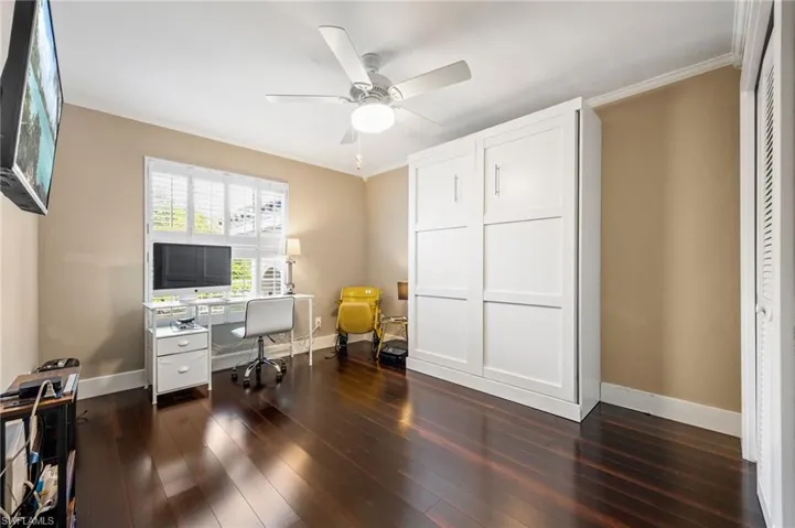 Office featuring ornamental molding, dark wood-style floors, and a ceiling fan