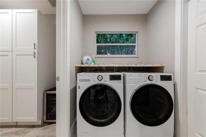 Laundry room featuring wine cooler and washing machine and dryer