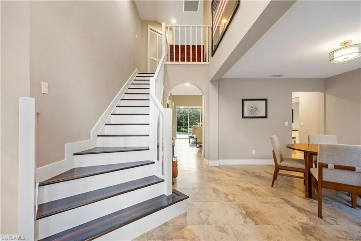Staircase with a high ceiling and arched walkways