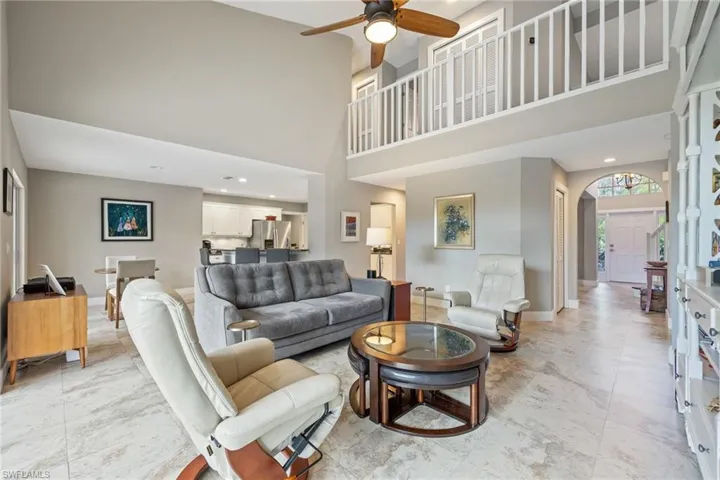 Living area featuring a towering ceiling, recessed lighting, and a ceiling fan