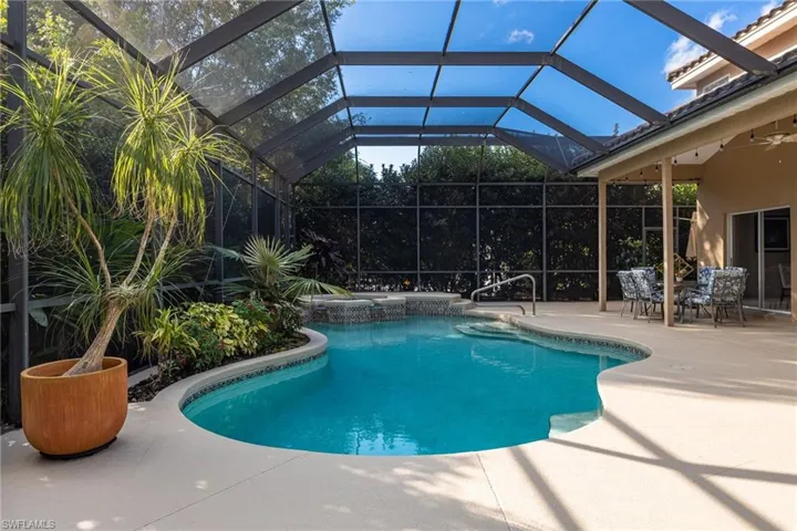 View of swimming pool featuring a sunroom, a patio, and glass enclosure