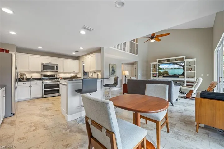 Dining area featuring ceiling fan, recessed lighting, and a high ceiling