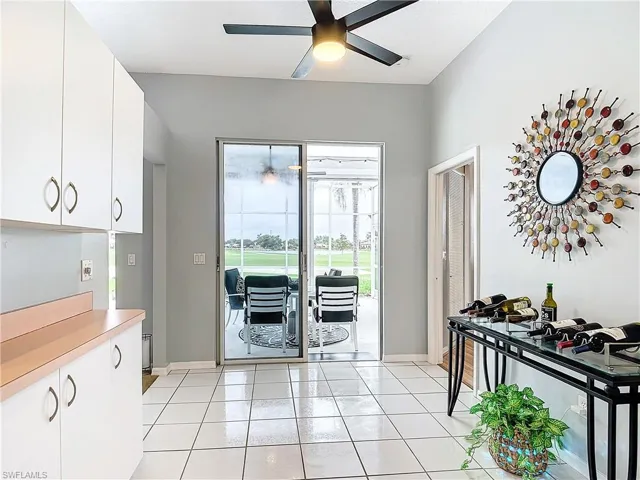 Kitchen featuring white cabinets, ceiling fan, and light tile floors