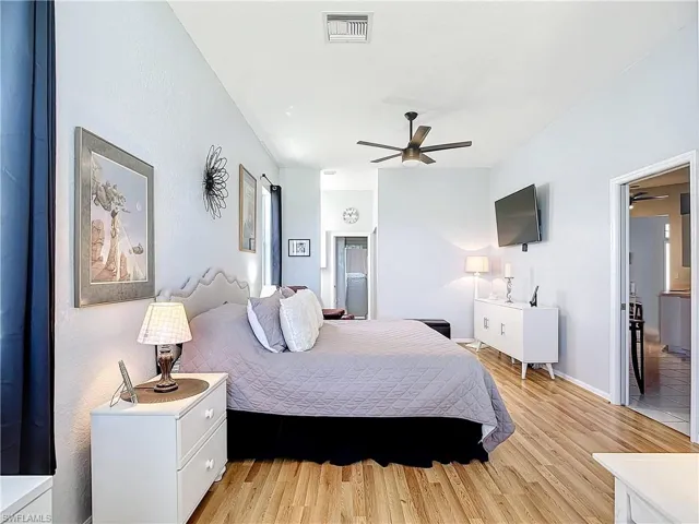 Primary Bedroom with ceiling fan and light hardwood / wood-style floors
