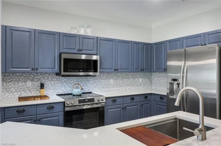 Beautifully updated kitchen with stainless steel appliances, counter height quartz counter tops & hexagon marble tiled backsplash.
