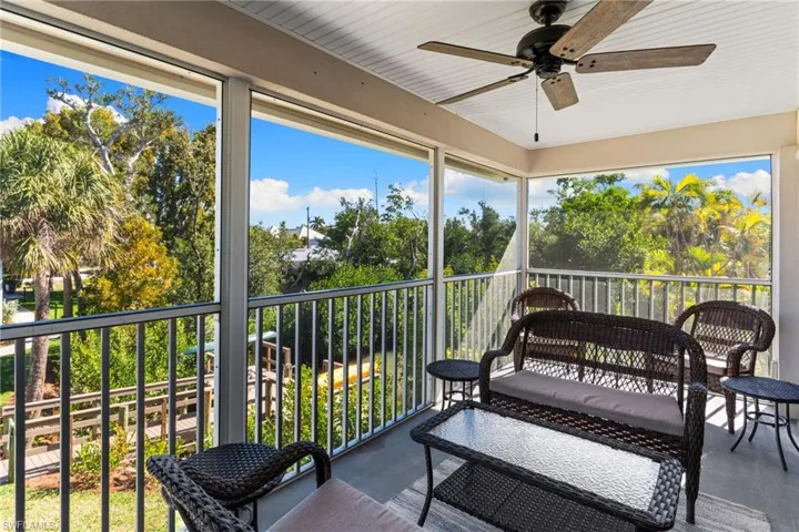 Sunroom featuring ceiling fan, healthy amount of natural light, and a balcony