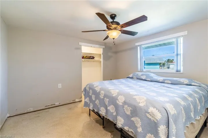 Bedroom featuring light carpet, ceiling fan, and a closet