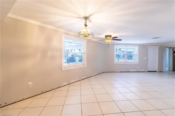 Tiled spare room with ornamental molding and ceiling fan