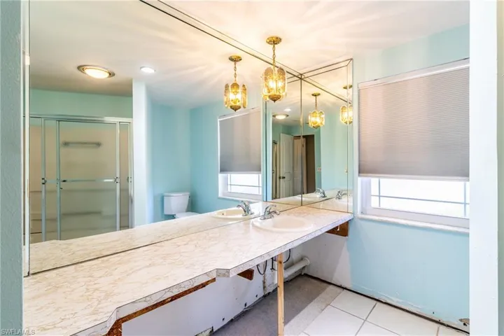 Bathroom featuring sink, an enclosed shower, and toilet