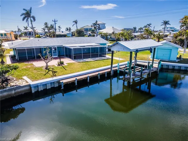 View of dock with a lawn and a water view