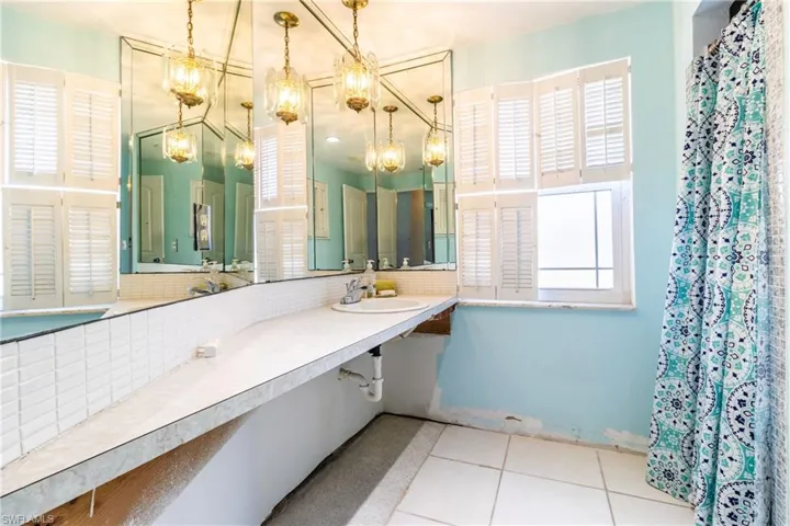 Bathroom featuring tile patterned flooring, sink, and backsplash