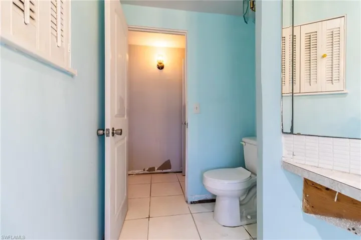 Bathroom featuring toilet, tile patterned flooring, and decorative backsplash