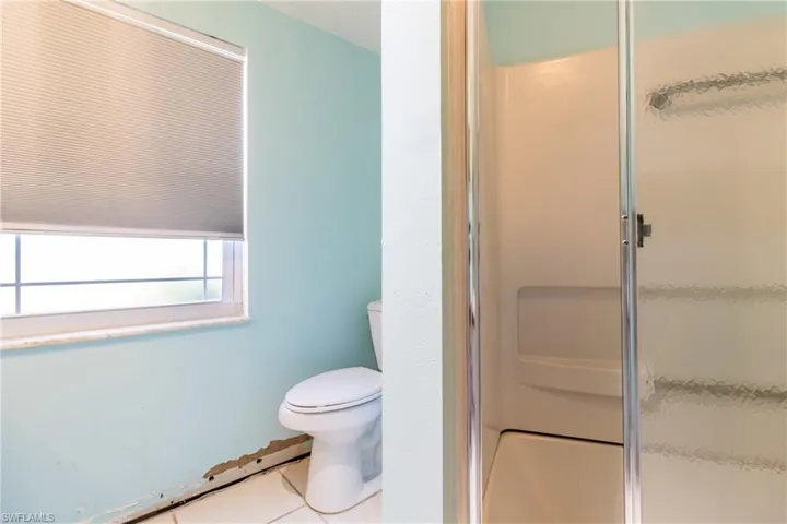Bathroom featuring tile patterned floors, toilet, and walk in shower