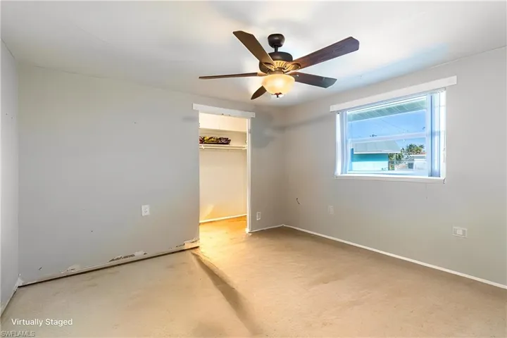Unfurnished bedroom with a walk in closet, a closet, and ceiling fan