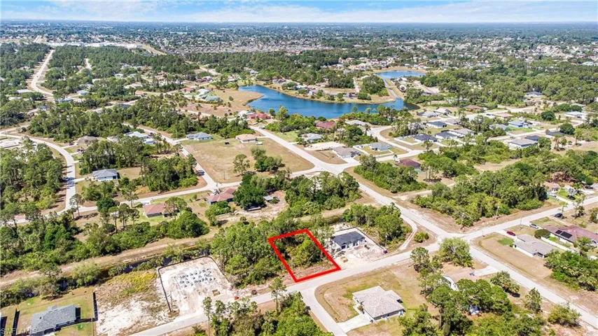Aerial perspective of suburban area featuring property boundaries highlighted and a nearby body of water