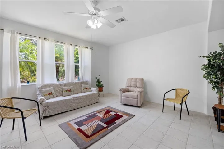Living area with a ceiling fan and light tile patterned floors