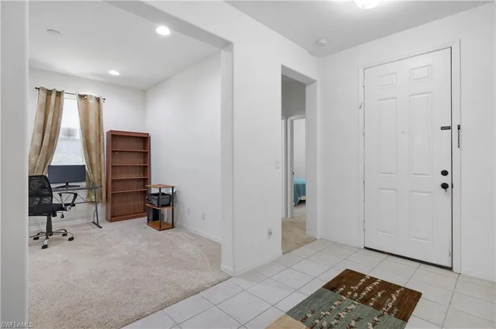 Entrance foyer featuring light carpet, light tile patterned floors, and recessed lighting