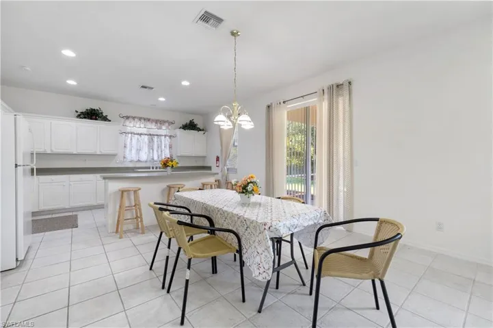 Dining room featuring a chandelier, light tile patterned flooring, and recessed lighting
