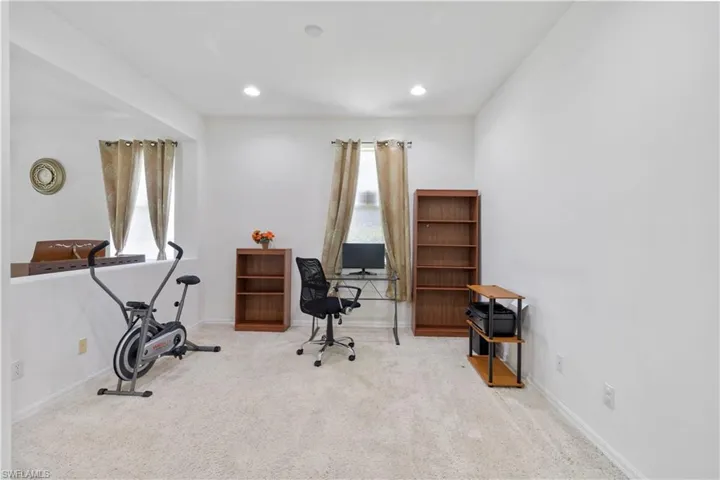 Carpeted office space featuring baseboards and recessed lighting