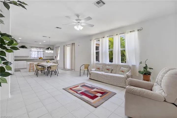 Living room featuring light tile patterned flooring and a ceiling fan