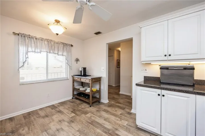 Kitchen featuring ceiling fan, white cabinetry, and light hardwood / wood-style floors