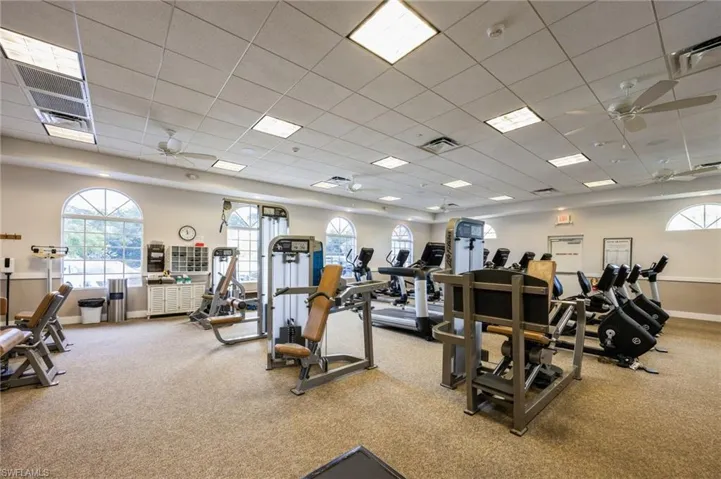 Workout area with carpet, ceiling fan, and a paneled ceiling