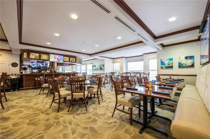 Dining room with plenty of natural light, coffered ceiling, carpet floors, and bar area