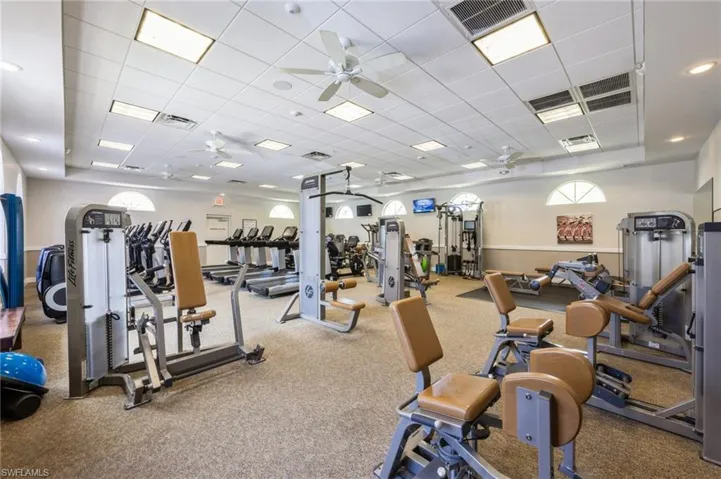 Workout area featuring a paneled ceiling, ceiling fan, and carpet floors