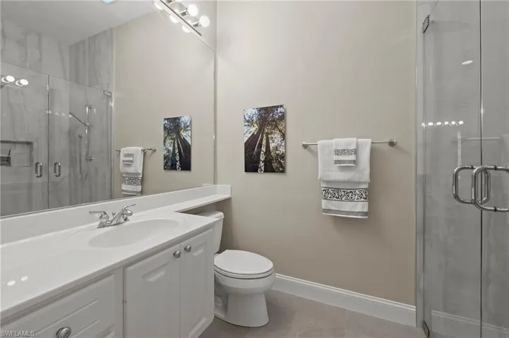 15402 Trevally Way Bonita Springs FL 34135 - Owner's bath updated with 24 X 48 inch porcelain tile in shower with seamless glass.