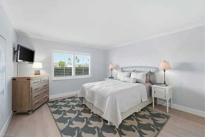 Bedroom with ornamental molding and light wood-style floors