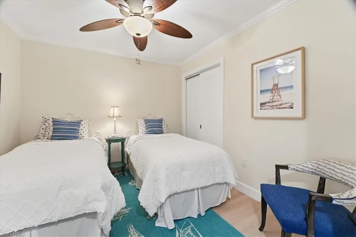 Bedroom with a closet, ornamental molding, and a ceiling fan