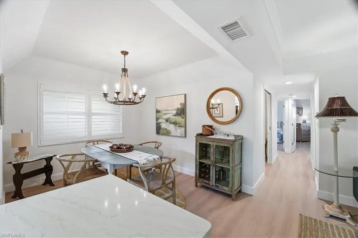 Dining space with light wood-style floors and a chandelier