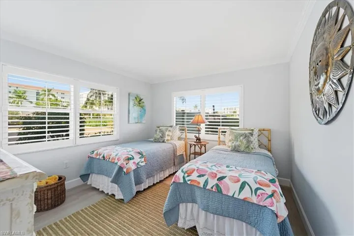 Bedroom featuring wood finished floors and ornamental molding