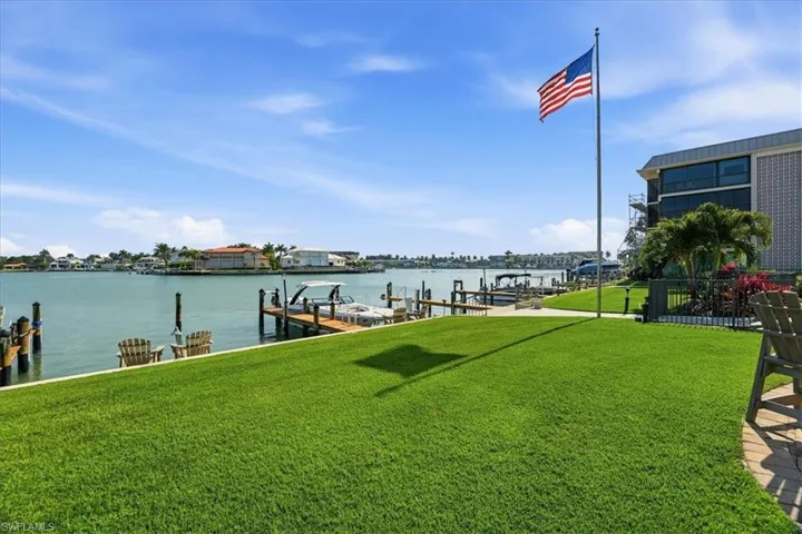 Dock area featuring a lawn, a water view, and boat lift