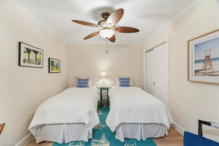 Bedroom featuring a closet, a ceiling fan, ornamental molding, and wood finished floors