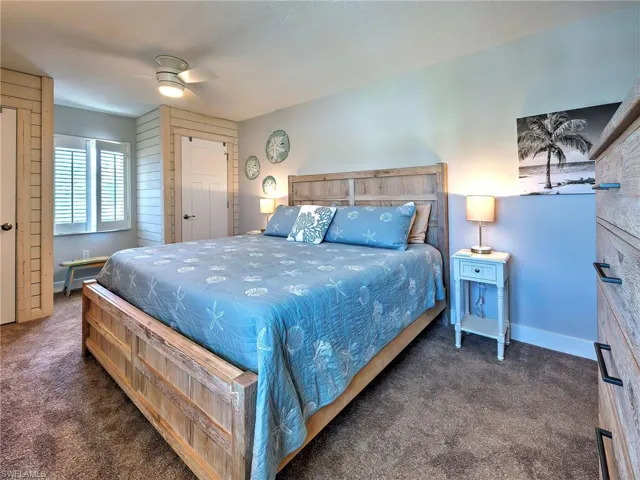 Bedroom with ceiling fan and dark colored carpet