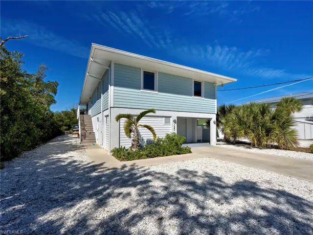 Coastal home featuring stairway and driveway