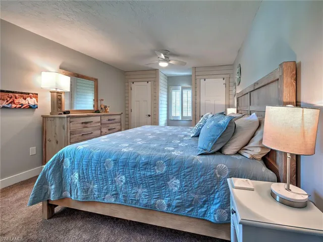 Bedroom featuring dark carpet, a ceiling fan, a closet, and a textured ceiling