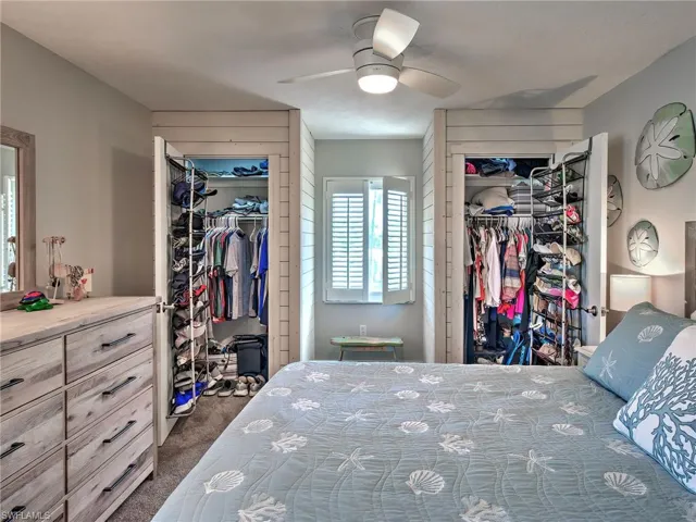 Bedroom with dark colored carpet and ceiling fan