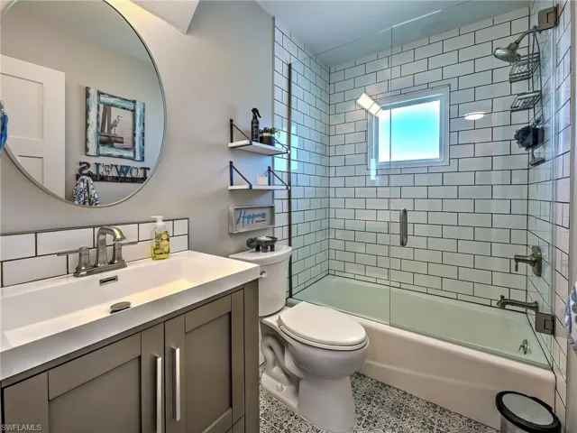 Bathroom featuring vanity and enclosed tub / shower combo