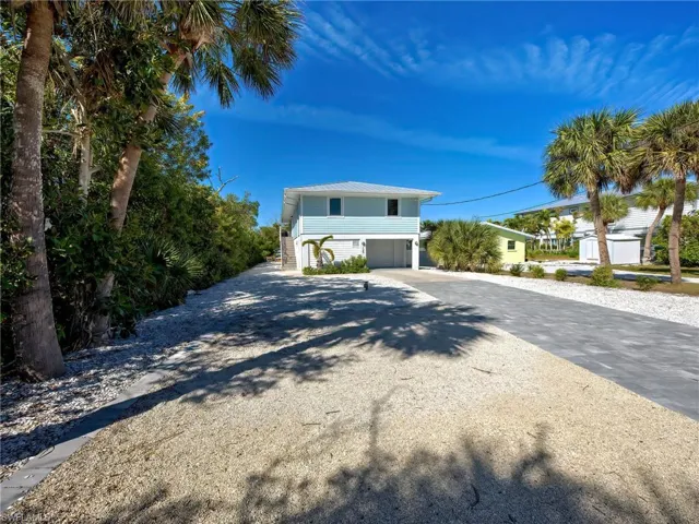 Coastal inspired home with driveway and a garage