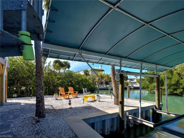 View of patio with a dock, a water view, and boat lift