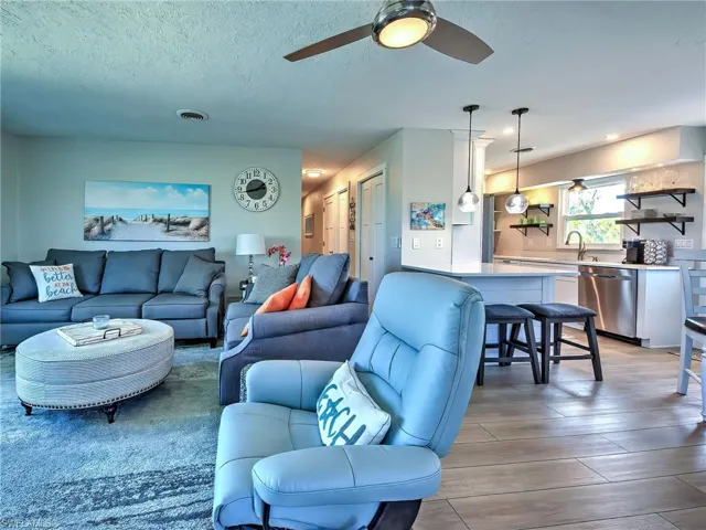 Living area featuring a ceiling fan and a textured ceiling