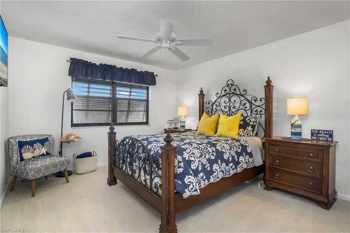 Master bedroom, carpeted floors,  with ceiling fan, decorative shutters.