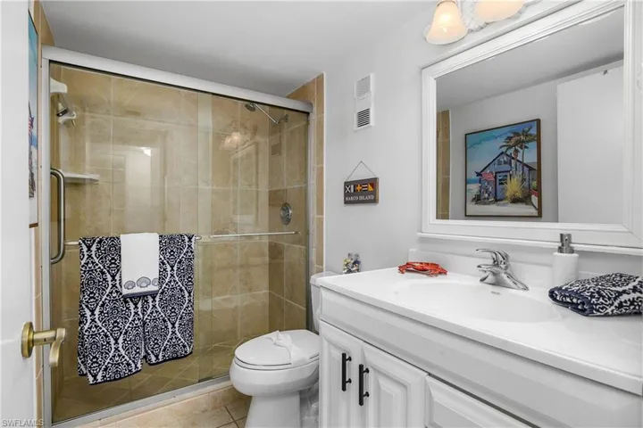 Master Bathroom with walk in shower, vanity, toilet, and tile patterned flooring.