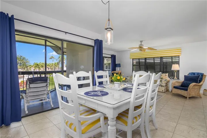Dining room with light tile patterned floors and ceiling fan. Or dine on the Lanai.